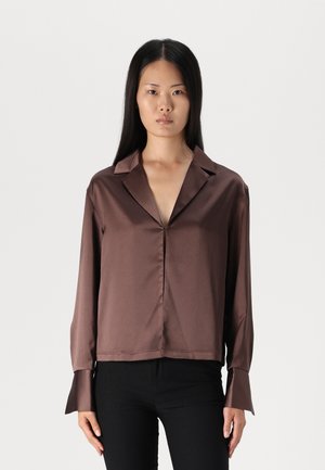 Brown satin long-sleeve shirt with a V-neckline and folded cuffs. Smooth texture with a loose fit and subtle sheen.