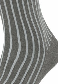 Calze grigie con strisce blu chiaro, realizzate in misto cotone, caratterizzate da una texture liscia e un design a coste. Notabili per il sottile contrasto di colore.