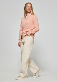 Ljusrosa zip-up sweatshirt med vit krage, kombinerad med krämfärgade vida byxor och beiga sneakers. Slät textur.