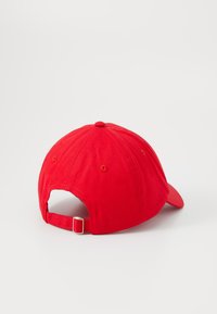 Rode katoenen honkbalcap met een gebogen rand, verstelbare band en een knoop bovenop. Stiksels en ventilatiegaten zijn zichtbaar.