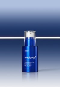 Flacone cilindrico blu di siero con tappo a pompa trasparente, etichettato "medicube One Day Exosome Shot 7500", caratterizzato da un design elegante e una finitura lucida.