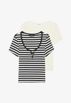 Două tricouri: unul crem și unul cu dungi orizontale negre și albe. Tricoul cu dungi are un decolteu rotunjit și accente cu nasturi.