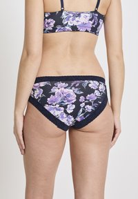 Blommig baddräktstrosor med marinblå bakgrund, prydda med lila blommor, spetsdetaljer och en åtsittande passform. Slät tygtextur.