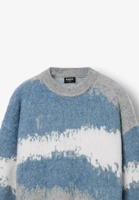 Sweter dziany z okrągłym dekoltem, z szarymi, niebieskimi i białymi paskami. Miękka tekstura i lekko luźny krój. Widoczna metka marki.