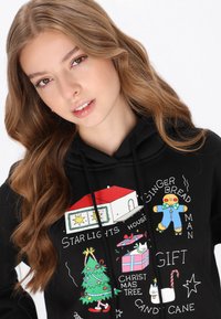 Sudadera con capucha negra con gráficos coloridos de temática navideña: hombre de jengibre, árbol de Navidad, regalos y estrellas. Tela suave, capucha con cordón ajustable.