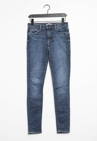 Úzké džíny v tmavě modré denimové barvě, vybavené designem s pěti kapsami, poutky na opasek a jemným vyblednutím. Vyrobeno s hladkým, texturovaným povrchem.