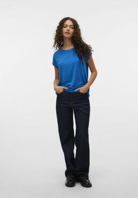 Blauwe shirt met korte mouwen van gladde stof, gecombineerd met hooggewaisted donkere denim wijde broek, met voorzakken en een relaxte pasvorm.