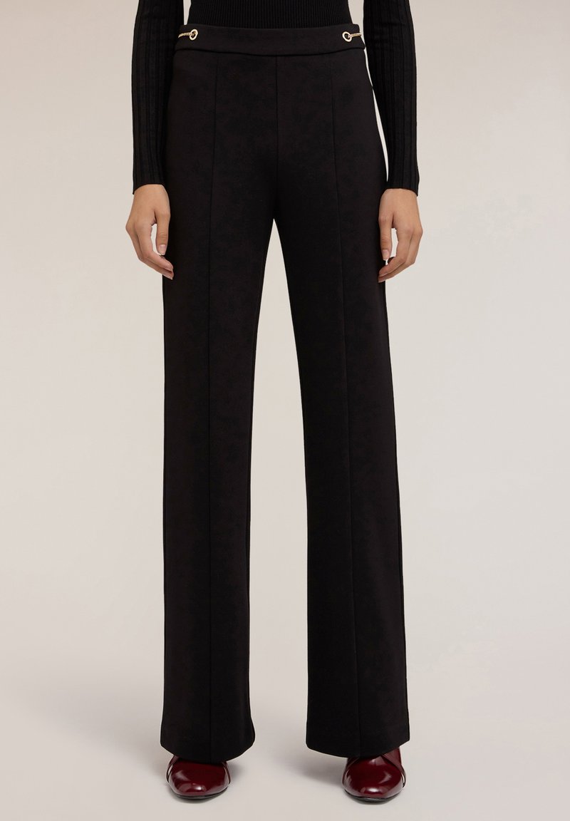Zwarte wijde broek van textuurstof met gouden hardware-accenten op de tailleband. Getailleerde pasvorm met voornaaddetails.