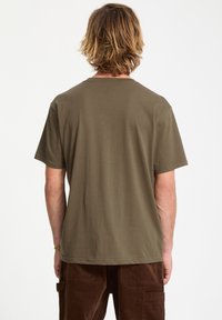 Olive green cotton t-shirt with a crew neck and short sleeves. Simple design with a straight cut and minimal stitching on the neckline.