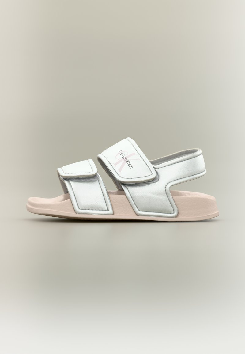 Λευκό και ανοιχτό ροζ σανδάλι Calvin Klein με ανοιχτό δάχτυλο, δύο ρυθμιζόμενα λουριά και μαλακή σόλα, απεικονίζεται από πλάγια όψη.