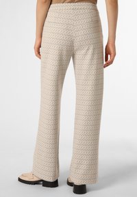 Wide-leg pants made from a textured, cream fabric with a geometric pattern in light tan. Features a flat waistband and back pockets.