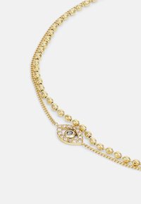 Goldkette mit Perlenverbindungen, einem Kettendesign und einem zentralen Anhänger in Form eines Auges, akzentuiert mit runden Steinen und Kristallen.