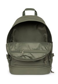 Mochila de tela verde olivo con parte superior redondeada, cierre de cremallera, bolsillo externo con cremallera y correas laterales ajustables. El interior incluye un bolsillo plano.