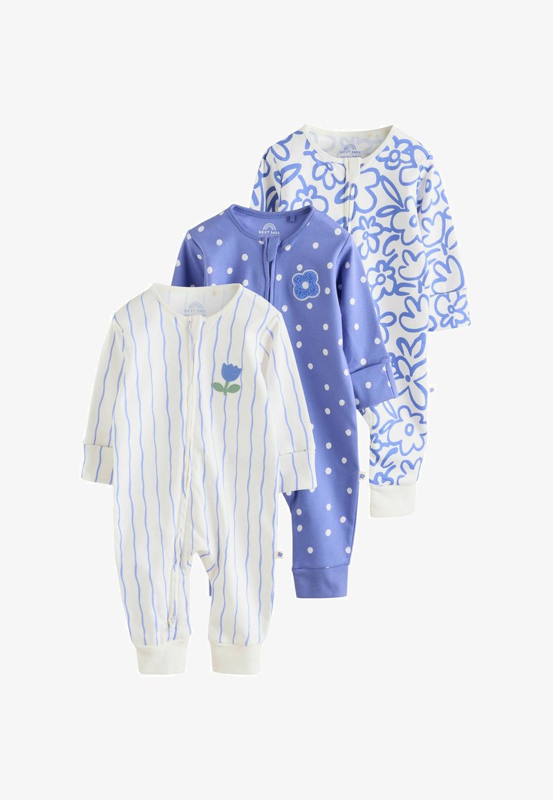 Trois grenouillères bébé à manches longues : blanche avec des rayures verticales bleues et une fleur, bleue à pois blancs avec un patch fleur, et blanche à imprimé floral bleu.