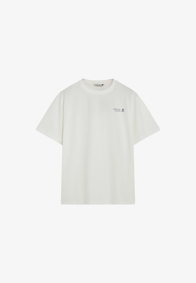 T-shirt blanc à manches courtes avec col rond, petit texte "Creative Studio" et logo de crâne sur le côté gauche de la poitrine.