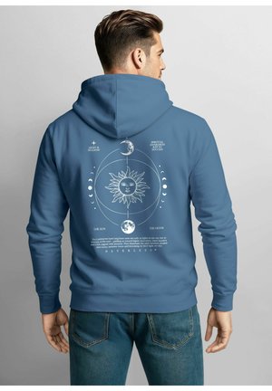 Kapuzensweatshirt in Blau mit einem himmlischen Design auf der Rückseite, einschließlich Sonne und Mond, mit weißen Texten und Grafiken.
