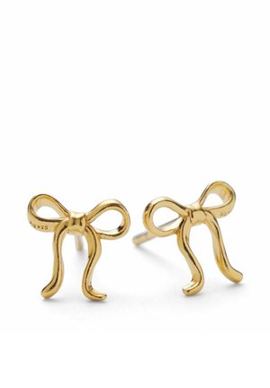 Cercei din metal auriu, sub formă de fundițe delicate cu capete curbate, expuși pe un fundal alb.