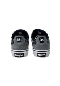 Grå ruskind sneakers med sorte accenter og en gummisål. Har et logo-patch på hælen og en struktureret mellemsål.