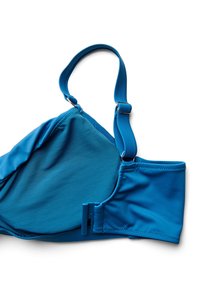 Modr pas za modrček z nastavljivo skodelico in zaponko z zankami na belem ozadju.