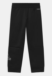 Mustat collegehousut, joissa on joustava vyötärö, valmistettu sileästä materiaalista. Ominaisuuksiin kuuluu valkoinen logo ja korostukset lahkeiden alaosassa.