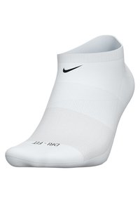 Calza sportiva bianca con corpo testurizzato, polsino a coste e logo. Presenta una punta liscia e l'etichetta "Dri-FIT" sulla suola.