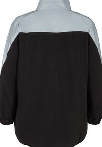 Veste noire et bleu clair avec un col haut, texture douce et poignets élastiques. Présente un design à blocs de couleurs avec une partie supérieure lisse.