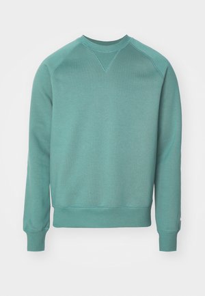 Tyrkysová mikina s okrúhlym výstrihom, raglánovými rukávmi, rebrovanými manžetami a lemovaním; vyrobená z mäkkej tkaniny s hladkou textúrou.