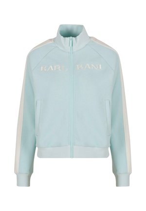 Hellblaues Reißverschlussjacke aus weichem Stoff mit hohem Kragen, versehen mit weißen seitlichen Streifen und "KARL KANI" auf der Vorderseite gestickt.