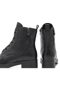 Stivali alla caviglia in pelle nera con lacci anteriori, cerniera laterale, superficie testurizzata e un solido tacco a blocco.