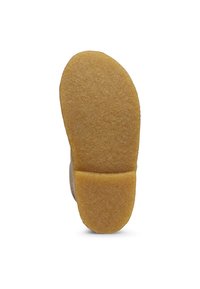 Sula av en ljusbrun sko med en texturerad yta, med en rundad form och en mjuk kontrast mellan häl- och tåområdet.