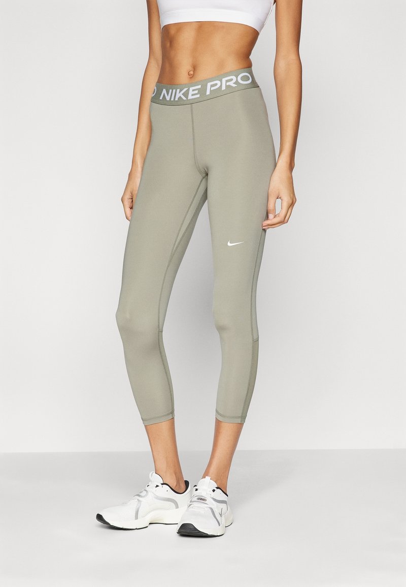 Nike Pro kvinders cropped leggings i dæmpet oliven grøn, med en høj talje og lysegrå branding, glat tekstur og tætsiddende design.
