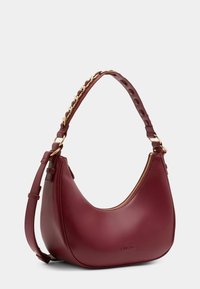 Borsa a tracolla in pelle borgogna con forma curvata, hardware dorato, chiusura con zip e tracolla accentuata da catena con finitura testurizzata.