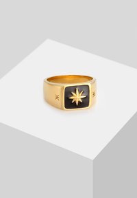 Gold-tone ring with a rectangular black stone featuring a starburst design. Textured accents on the sides enhance its geometric shape.