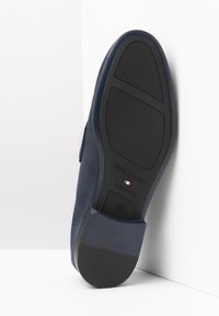 Dunkelblauer Wildlederschuh mit Gummisohle, strukturiertem Muster an der Unterseite und dem Etikett "NeroGiardini Made in Italy". Größe 42.