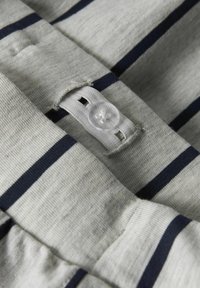 Tessuto grigio con strisce orizzontali blu navy, dotato di un bottone in plastica bianca e un dettaglio di asola a chiave, texture a costine lungo i bordi.
