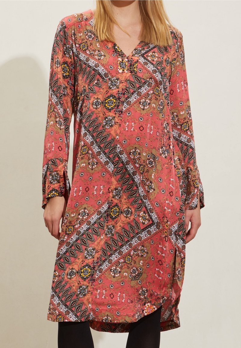Vestido rojo estampado con mangas largas, que presenta diseños florales y geométricos. Escote en V y corte holgado, hecho de una tela ligera.