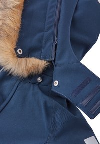 Marineblauwe buitenkleding met nep bontafwerking, ritskraag, drukknoopsluiting en gemêleerd materiaal. Voorzien van klittenbandaccenten op de mouwen.