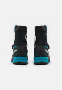 Czarne buty górskie z turkusowymi akcentami, z wysokim kołnierzem, textured powierzchnią, wyraźnym logo oraz trwałą konstrukcją podeszwy.