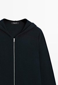 Dunkelblaue Zip-Hoodie aus weichem Stoff mit einer geräumigen Kapuze, tonal abgenäht und mit einem silbernen Reißverschluss.