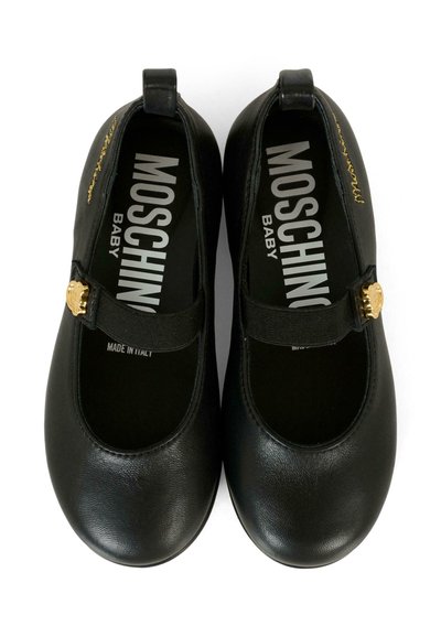 Chaussures pour bébé en cuir noir avec un bout arrondi, une sangle sur le coup de pied et un accent logo en doré. Texture lisse, talon plat, fabriquées en Italie.