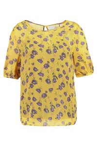 Blouse florale jaune à manches courtes avec un motif de fleurs violettes, décolleté rond et une petite ouverture en forme de clé dans le dos.