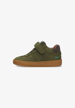 Groene suedinen sneaker met een klittenbandsluiting, bruine accenten, een gestructureerde rubberen zool en teal stippen op de hiel.