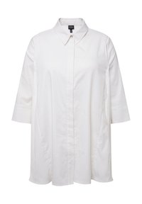 Camicia bianca in cotone con colletto, chiusura con bottoni e maniche 3/4. Presenta una vestibilità ampia e una texture liscia, adatta per essere indossata a strati.