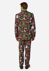 Krāsains Ziemassvētku tematika uzvalks ar melnu pamatni, kurā ir koku, dāvanu, Santa Klausa un piparkūku vīriešu motīvi. Izgatavots no gludas auduma.