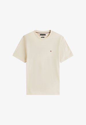 Beežist puuvillast t-särk ümmarguse kaelusega ja lühikeste varrukatega. Lõhule väikese logoga. Pehme tekstuuriga, vaba lõikega.