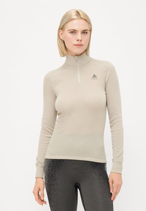 Langermet skjorte med høy krage i lys beige, med halv glidelås og teksturert stoff. Merkevarelogo på brystet, slim fit design.