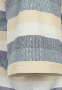 Tkanina w paski z poziomymi pasami w jasnym beżu, kremowym oraz w różnych odcieniach niebieskiego, o textured powierzchni i wykończonym brzegu.