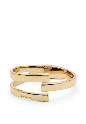 Pulsera de brazalete en tono dorado con un diseño abierto moderno, que presenta dos bandas paralelas que se estrechan en los extremos, ofreciendo un aspecto elegante y pulido.