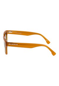 Gafas de sol naranjas y transparentes con un marco rectangular y patillas rectas. Presentan un logo en el lateral y un acabado suave y brillante.