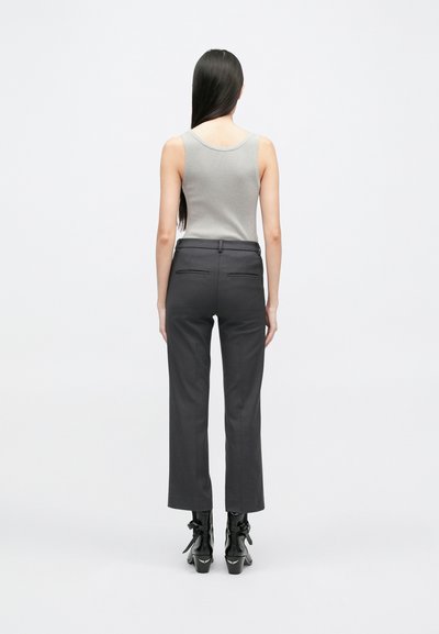 Hallakujuline hall kampsun, millele on sobitatud tumehallad talje järgi lõigatud püksid. Püksid on slim fit stiilis, keskmise kõrgusega talje ja kahe tagataskuga. Mustad kontsad.